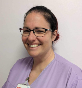 Gemma Sayer pictured wearing glasses and a purple tunic