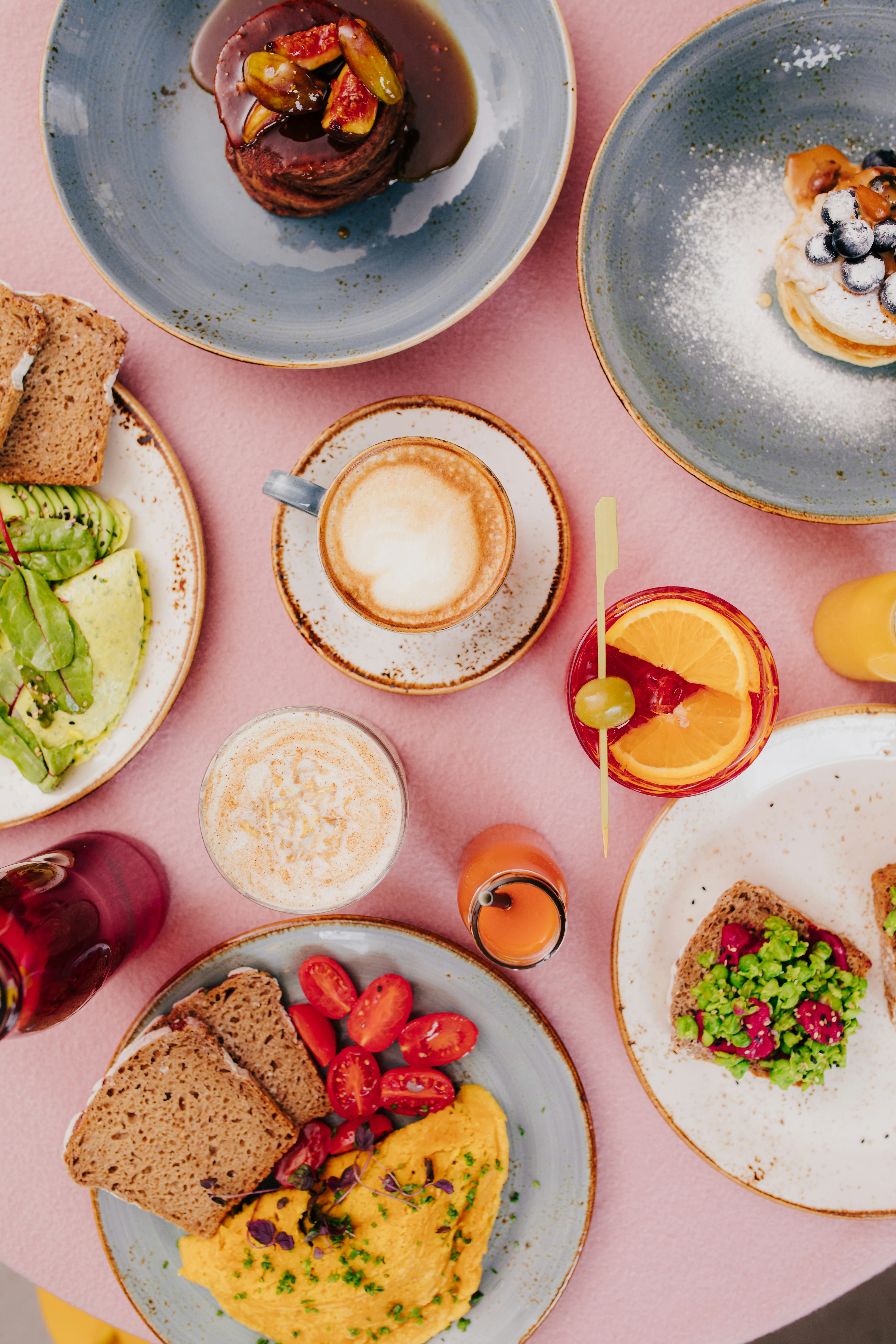 Table filled with brunch plates of brightly coloured food