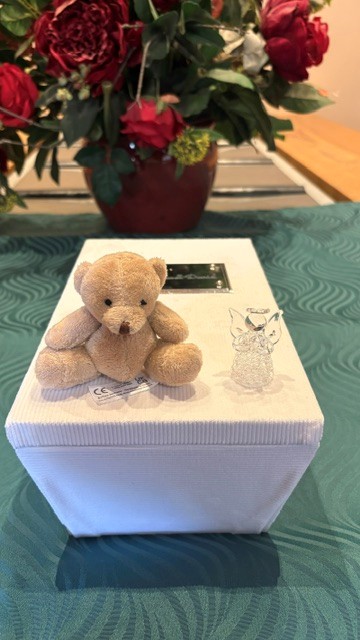 Esme’s urn with a teddy and angel after she was a second trimester loss at 23 weeks.
