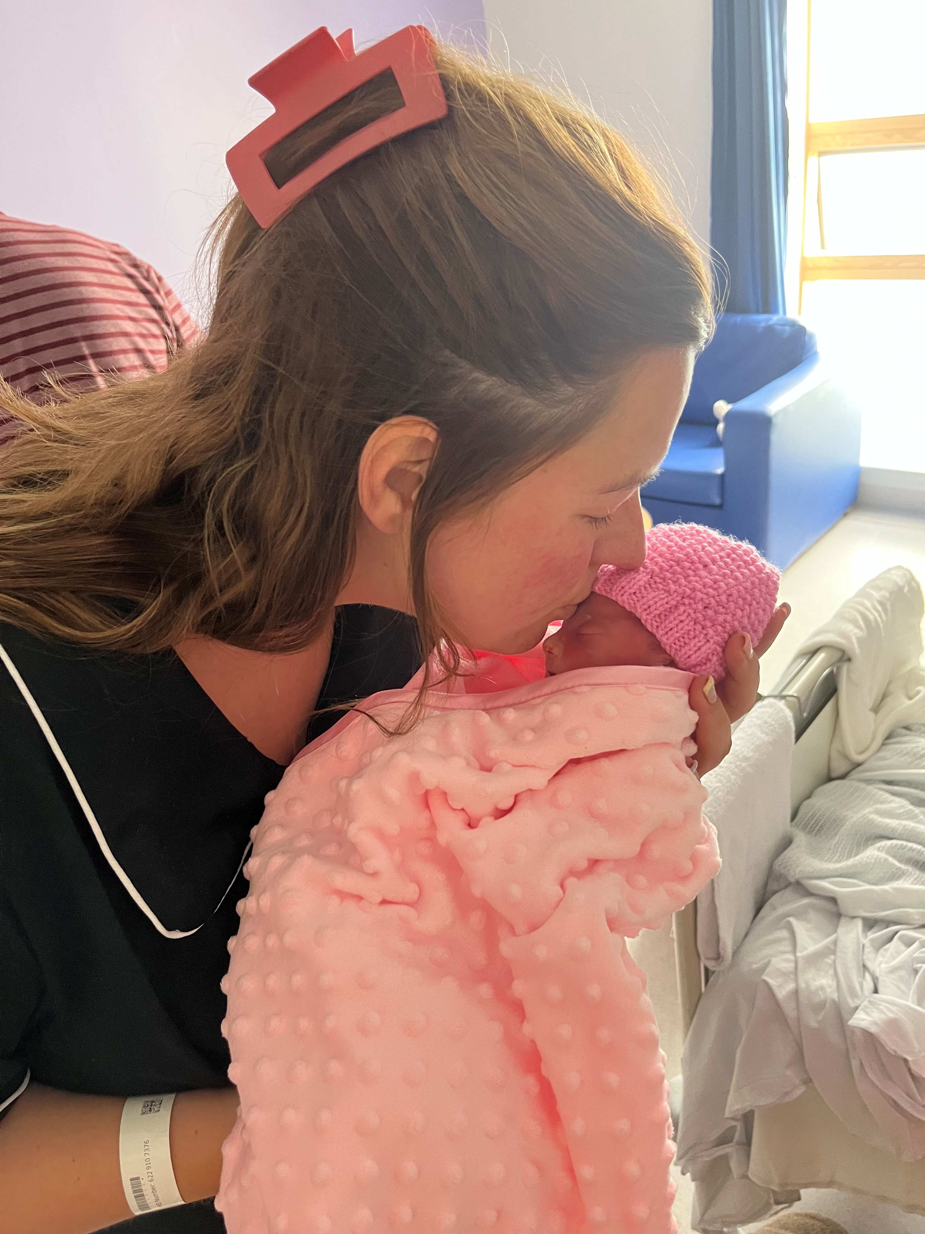 Jenny kisses her daughter Madison who was born sleeping and one of multiple losses.