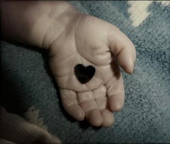 Aubrey’s hand holding a heart after care failed him.