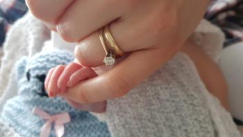 Jessica holding her son Jacob’s finger after his stillbirth.