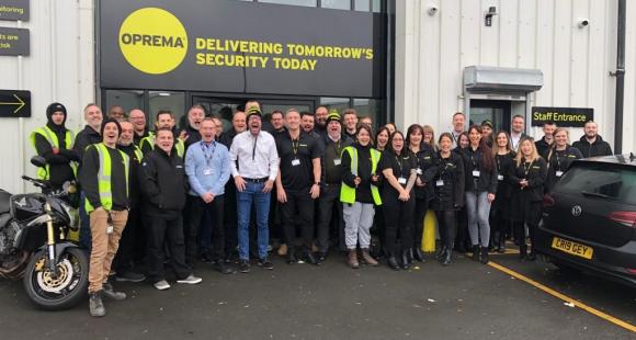 Around 30 Oprema staff members stood outside their office building smiling at the camera.