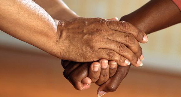 a zoomed in shot of 2 people holding hands