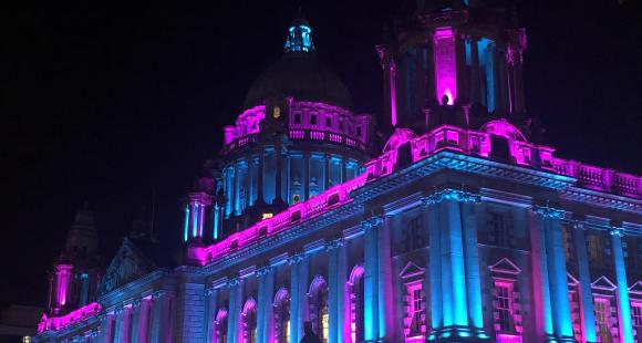 Image of a building lit up in pink and blue