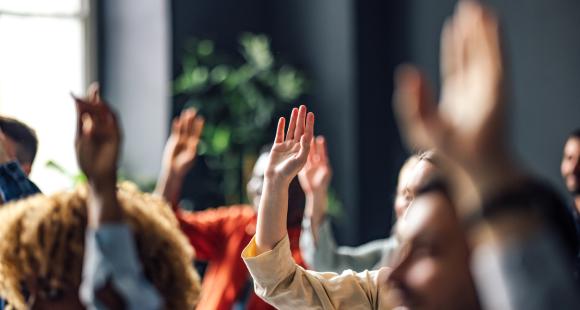 Hands raised at a meeting