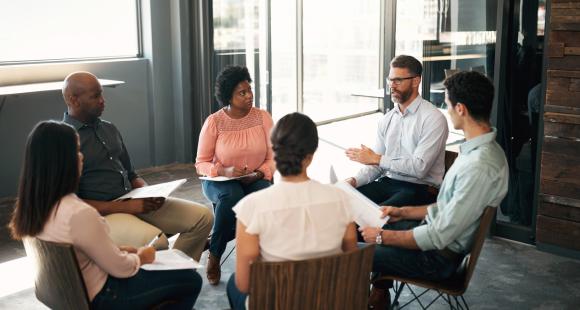 Group of men and women sitting in a circle having a discussion