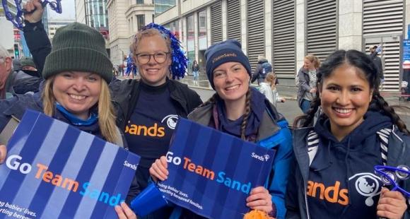 4 Sands supporters cheering in sands tshirts, holding posters