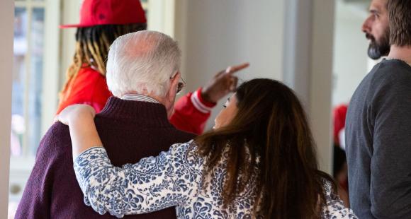A lady with her arm around an older gentlemen's shoulder