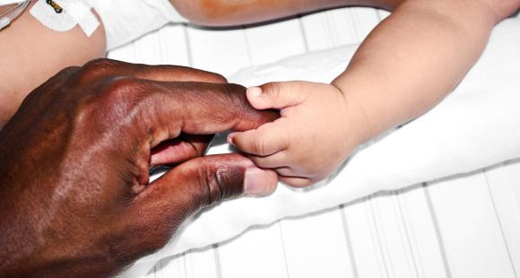 A parents hold is holding a baby's finger