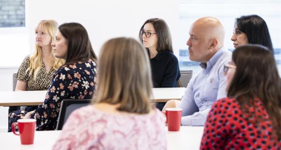 A group of people listening to a speech
