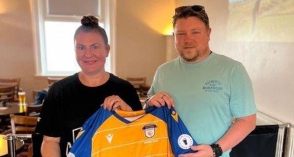 Alex holding up his Sands United shirt