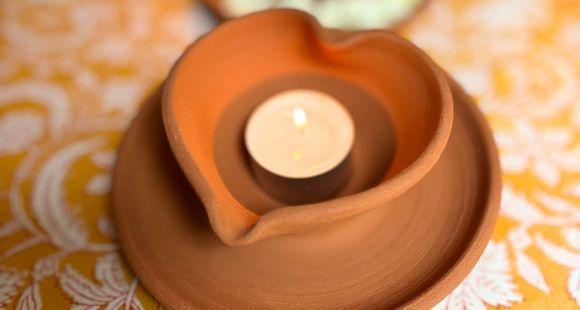 a heart-shaped diya with tea light candle