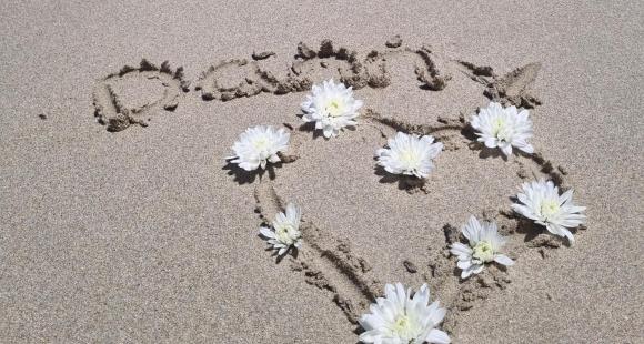 Danny's name spelt out in the sand on a beach for Say Their Name Day