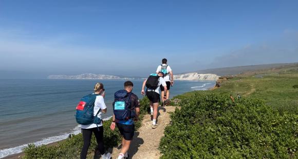 Group of people walking, blue sea and white cliffs.