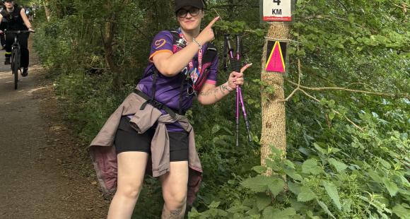 One women pointing at tree with a sign that say 4km