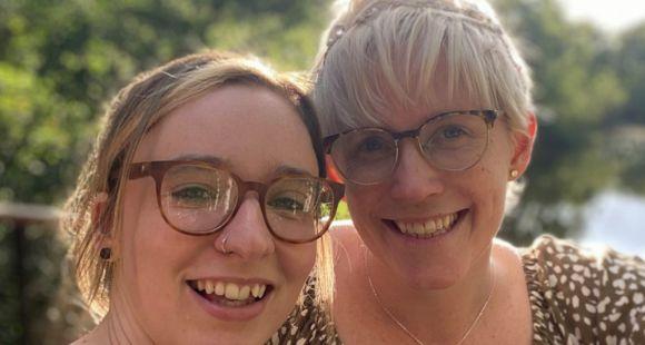 Two ladies wearing glasses smiling at the camera and sharing about their daughter's stillbirth.