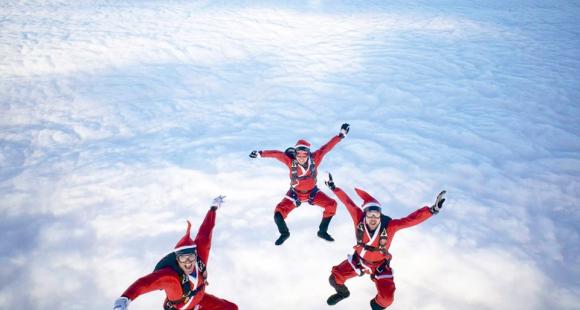 Three men in Santa Suits Falling though the sky 