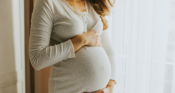 A pregnant woman holding her baby bump