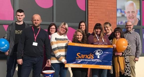 Payzone employees with Sands banner