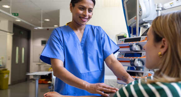 Image of pregnant woman and a doctor showing her a picture of a baby scan