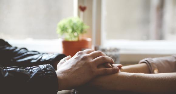 Hands across table