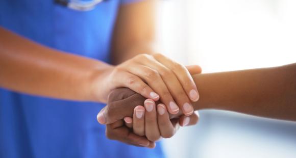 Health professional holds someone's hand