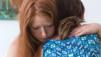Two women hug.