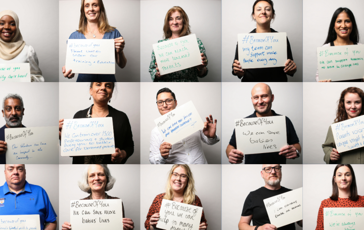 members of staff from Sands holding up handwritten signs with message of why Sands work is so important