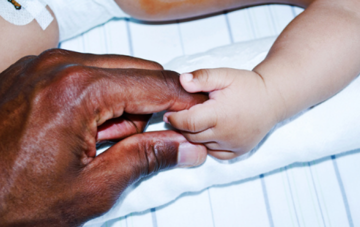 baby's hand holding adults finger