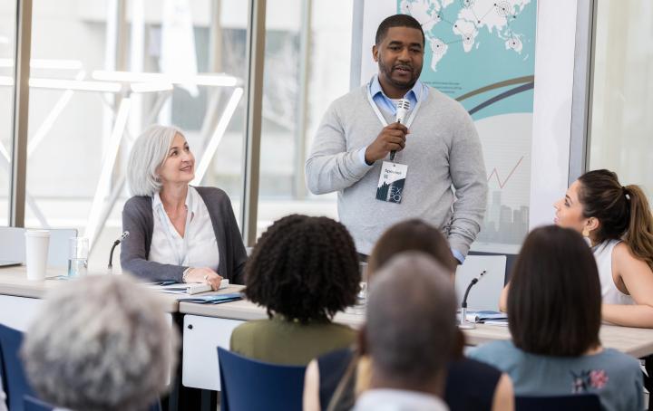 a man presenting his research finding to the group