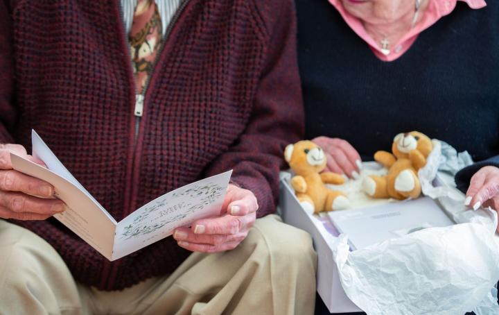 Couple sat together looking through support book 