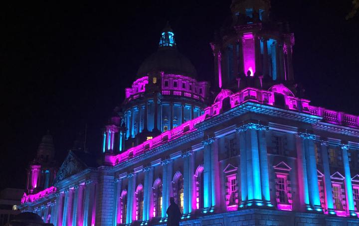 A building lit up in pink and blue