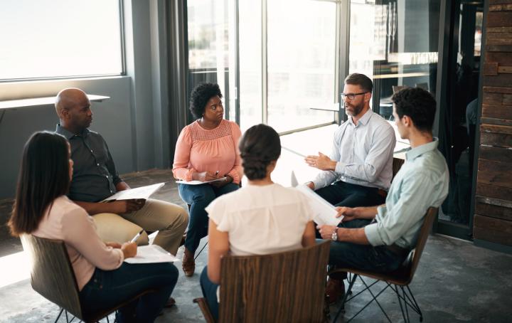 Group of men and women sitting in a circle having a discussion