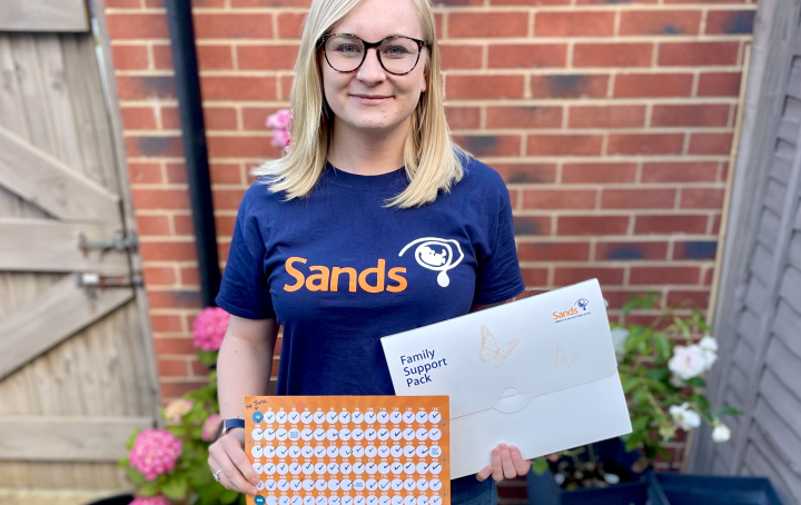 lady in sands t-shirt holding running tracker 