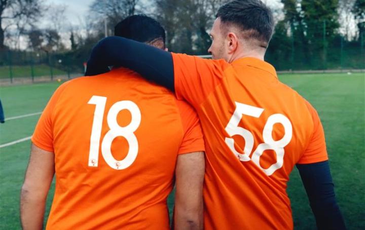 Two men stood together in their Sands United kits with one putting his arm around the other's shoulder