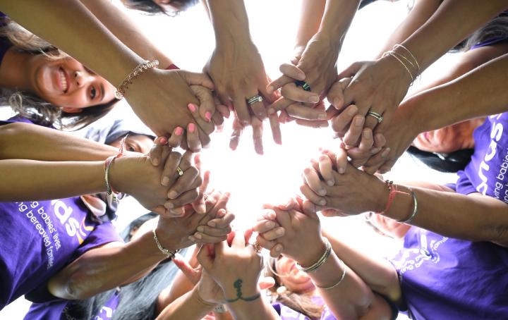 A group of parents stood in a circle holding hands