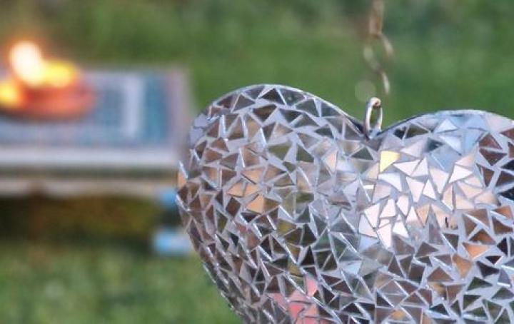 diya alight in a garden with a heart ornament