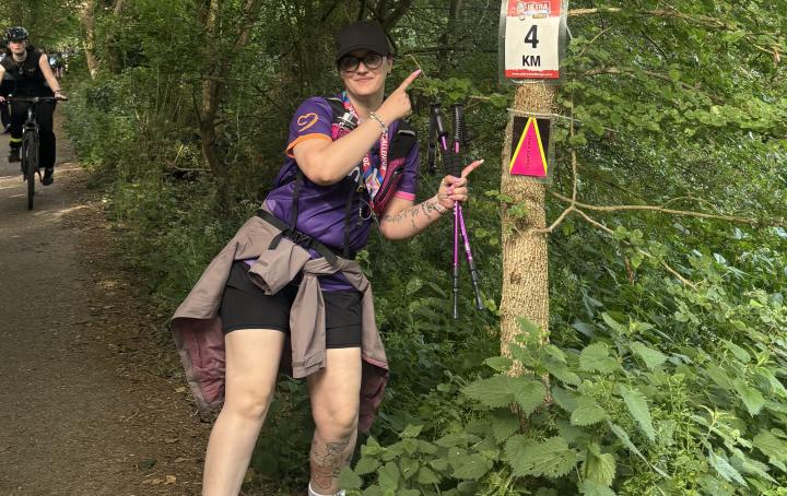 One women pointing at tree with a sign that say 4km