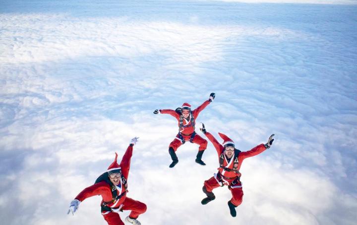 Three men in Santa Suits Falling though the sky 