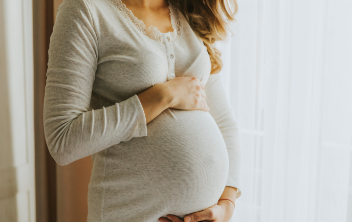 A pregnant woman holding her baby bump