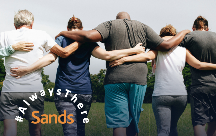 Sands Always There - people with arms around each others shoulders