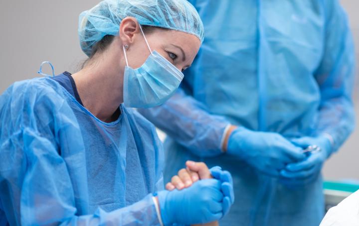 Supportive healthcare professional holds woman's hand