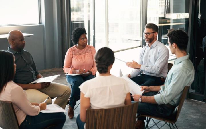 Group of men and women sitting in a circle having a discussion