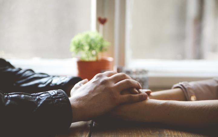 Hands across table